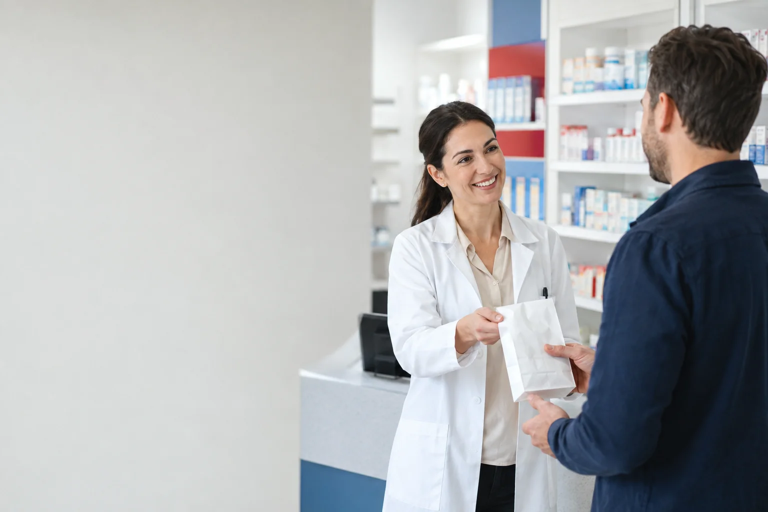 A pharmacist handing a prescription bag to a customer